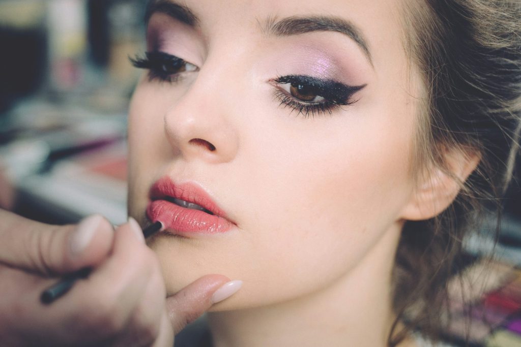 Lippenstift wird aufgetragen, Frau die geschminkt wird
