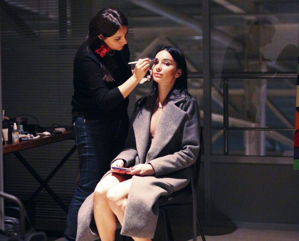 Eine Frau lässt sich von einer anderen Frau schminken.